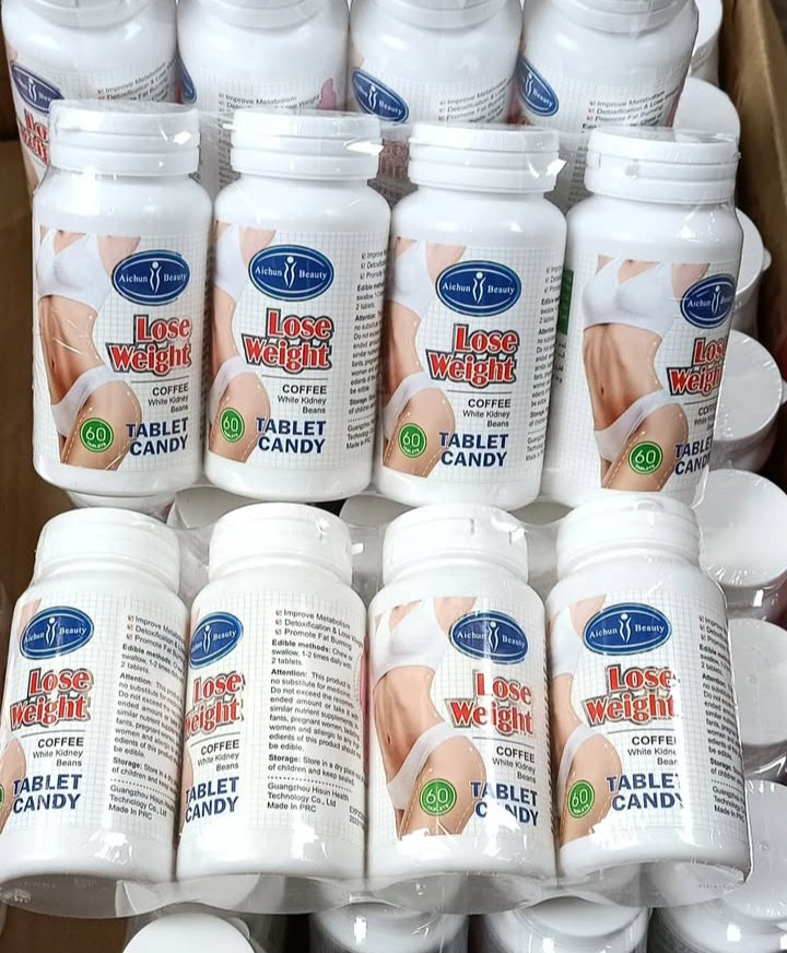 Multiple bottles of 'Lose Weight Tablet Candy' with visible branding and text.